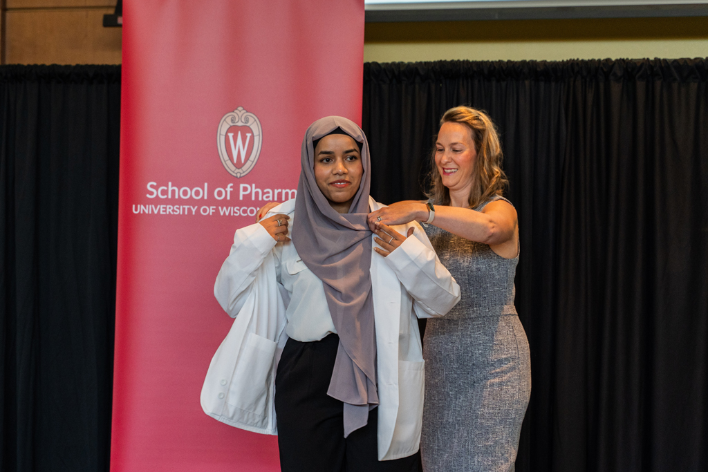 Photo by Paulius Musteikis A student receives her white coat from Kate Rotzenberg