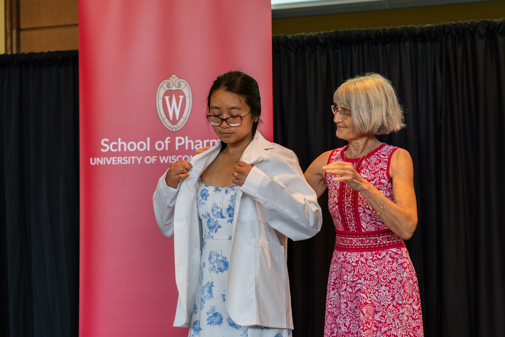 Photo by Paulius Musteikis A student receives her white coat from Mara Kieser