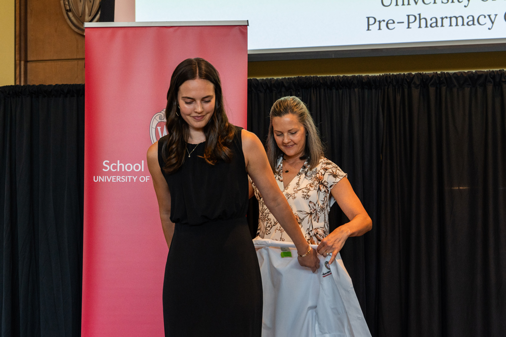 Photo by Paulius Musteikis A student receives her white coat from Kate Rotzenberg