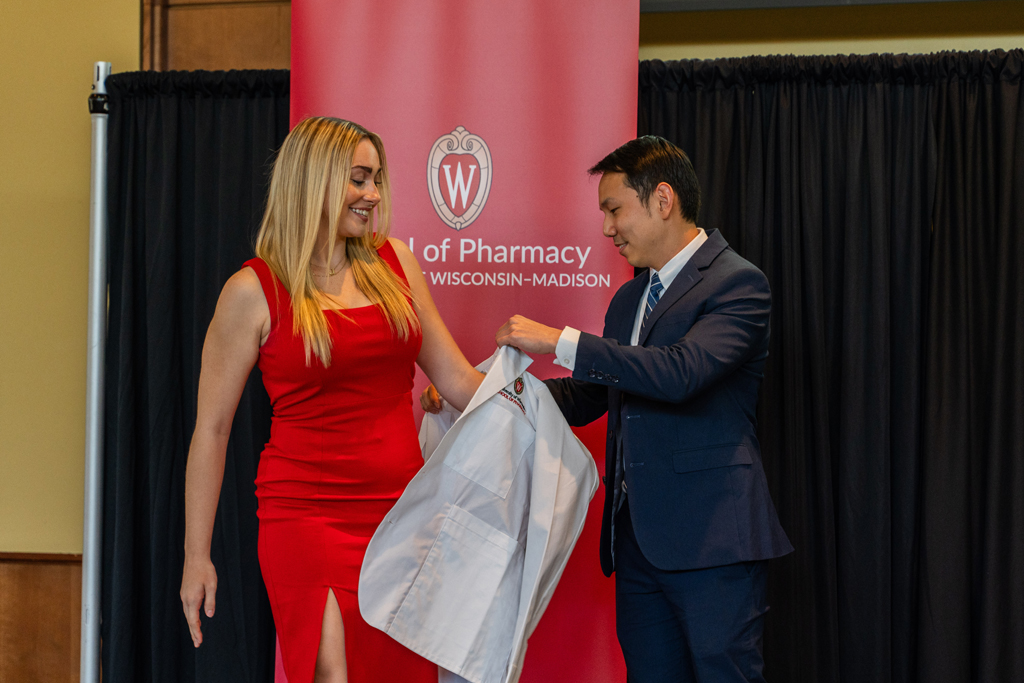Photo by Paulius Musteikis A student receives her white coat from Sean Lim