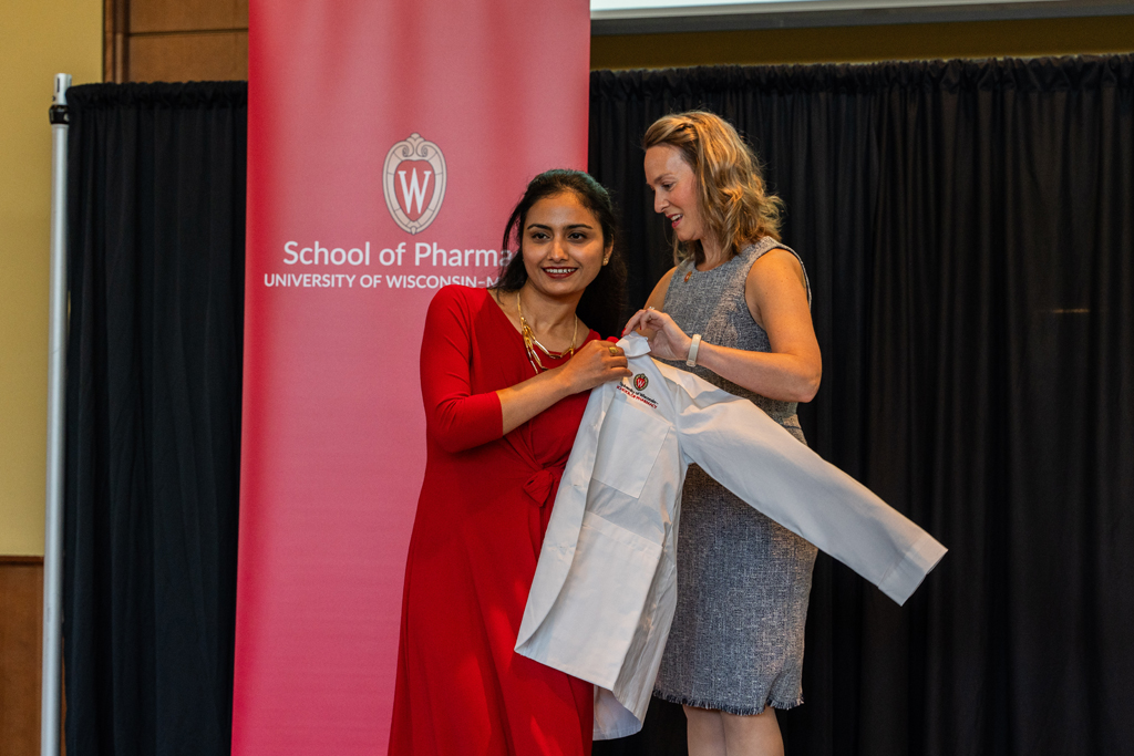 Photo by Paulius Musteikis A student receives her white coat from Kate Rotzenberg