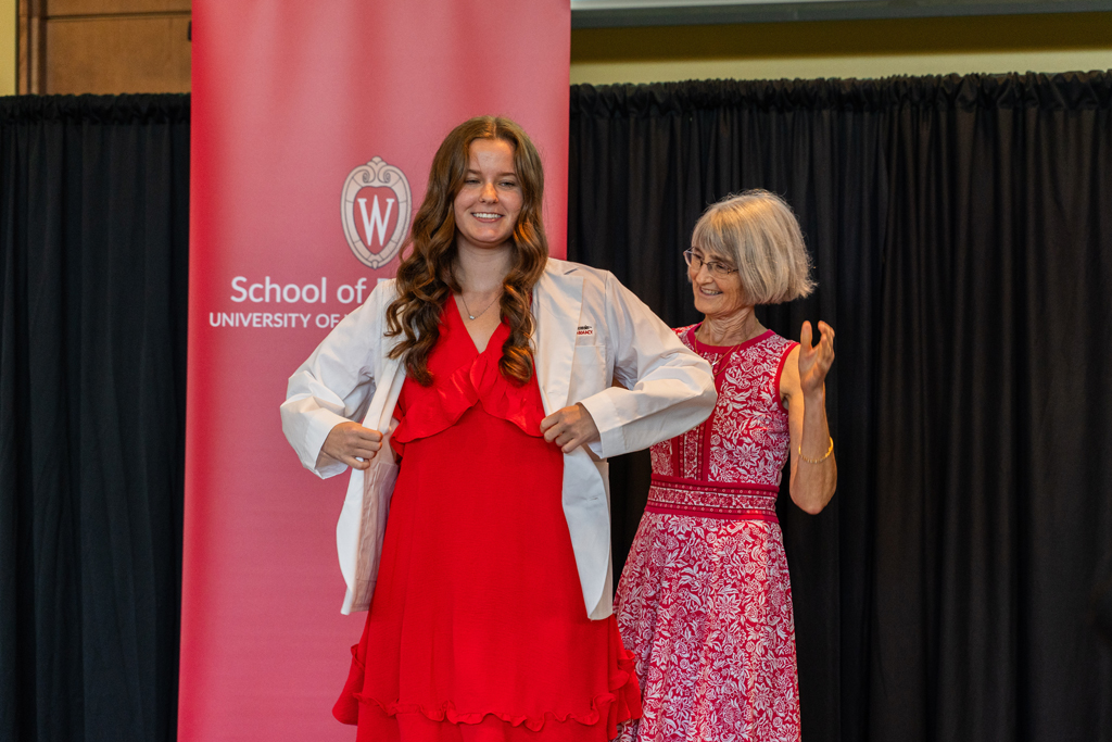 Photo by Paulius Musteikis A student receives her white coat from Mara Kieser