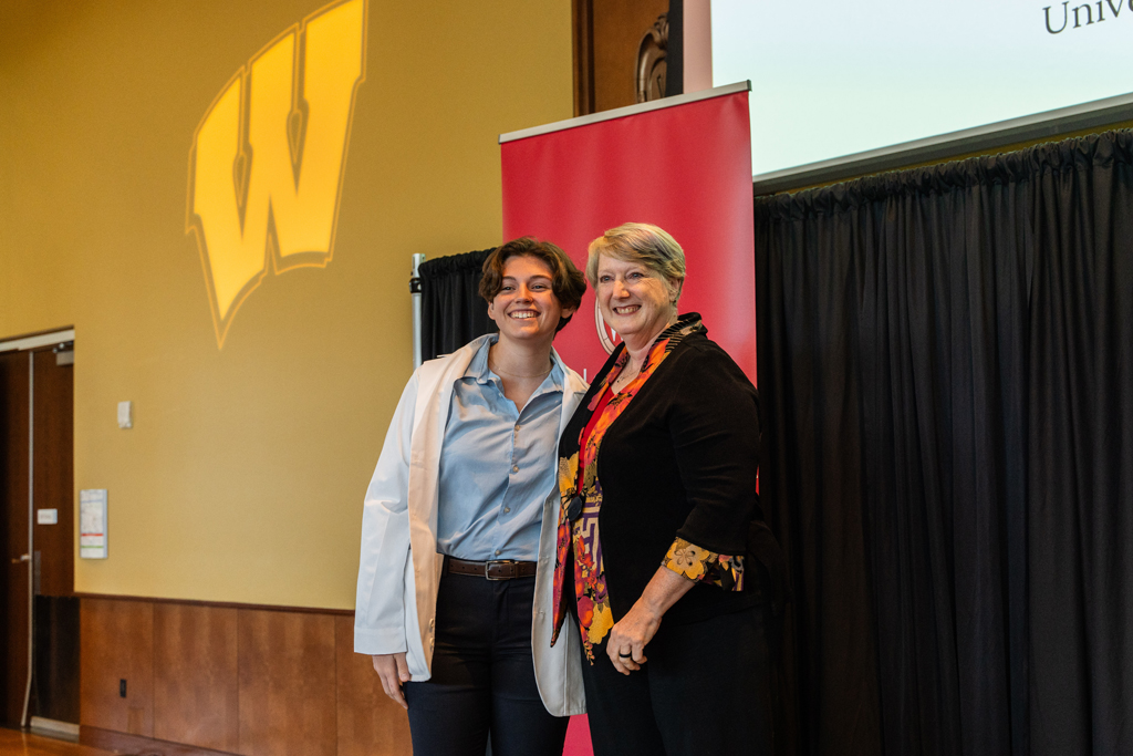 Photo by Paulius Musteikis A student poses with Karen Kopacek in front of red School of Pharmacy banner