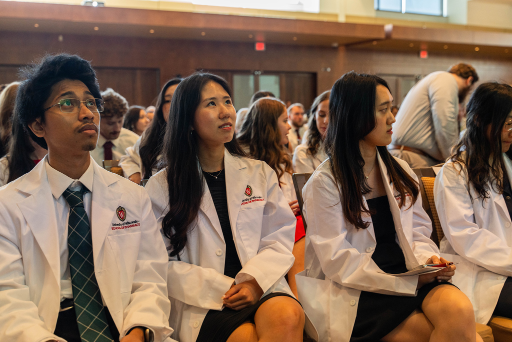 Photo by Paulius Musteikis Students in white coats look upward