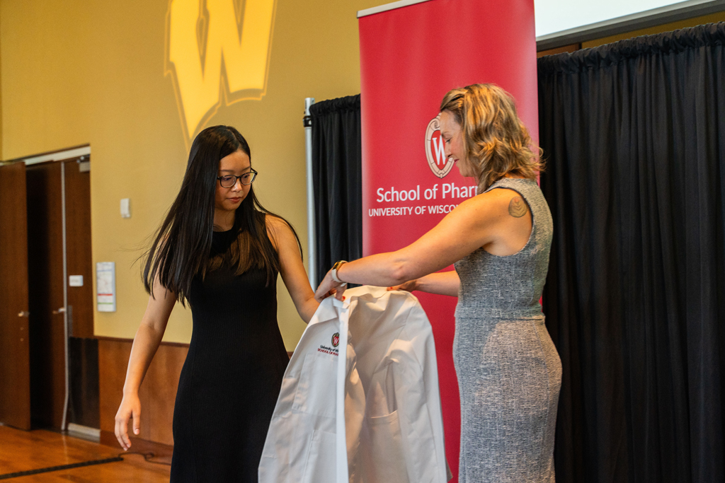 Photo by Paulius Musteikis A student receives her white coat from Kate Rotzenberg