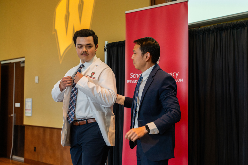 Photo by Paulius Musteikis A student receives his white coat from Sean Lim