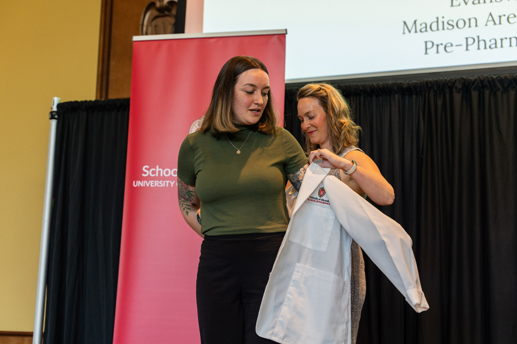 Photo by Paulius Musteikis A student receives her white coat from Kate Rotzenberg