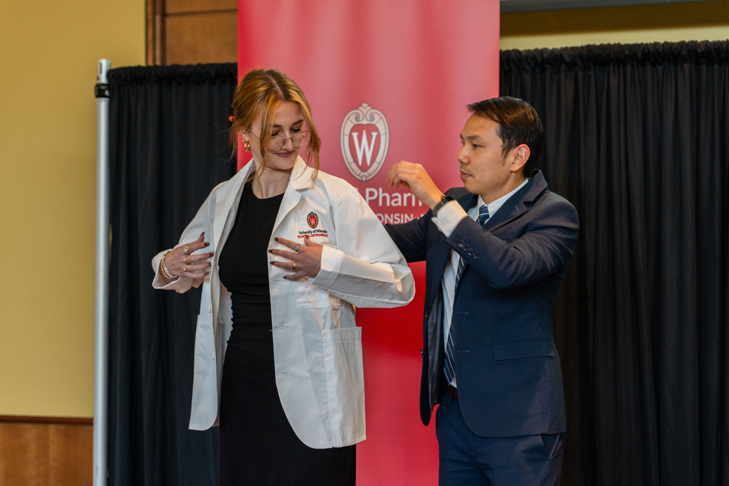 Photo by Paulius Musteikis A student receives her white coat from Sean Lim