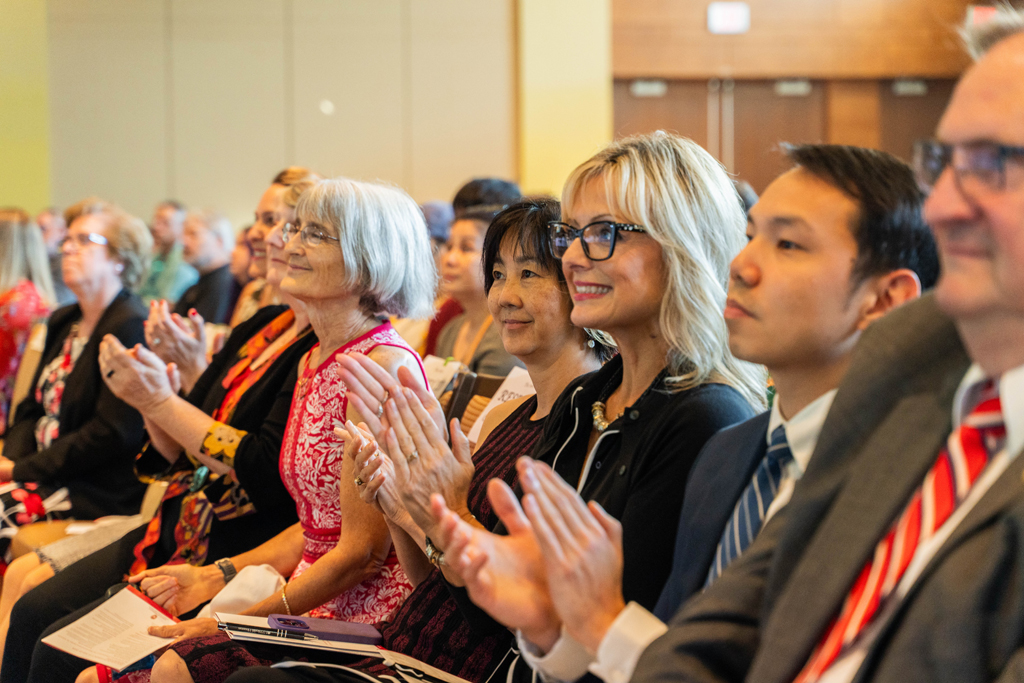 Photo by Paulius Musteikis Faculty and staff — including Kate Rotzenberg, Karen Kopacek, Mara Kieser, Michelle Chui, Beth Martin, Sean Lim, and Dean Steve Swanson, applaud.