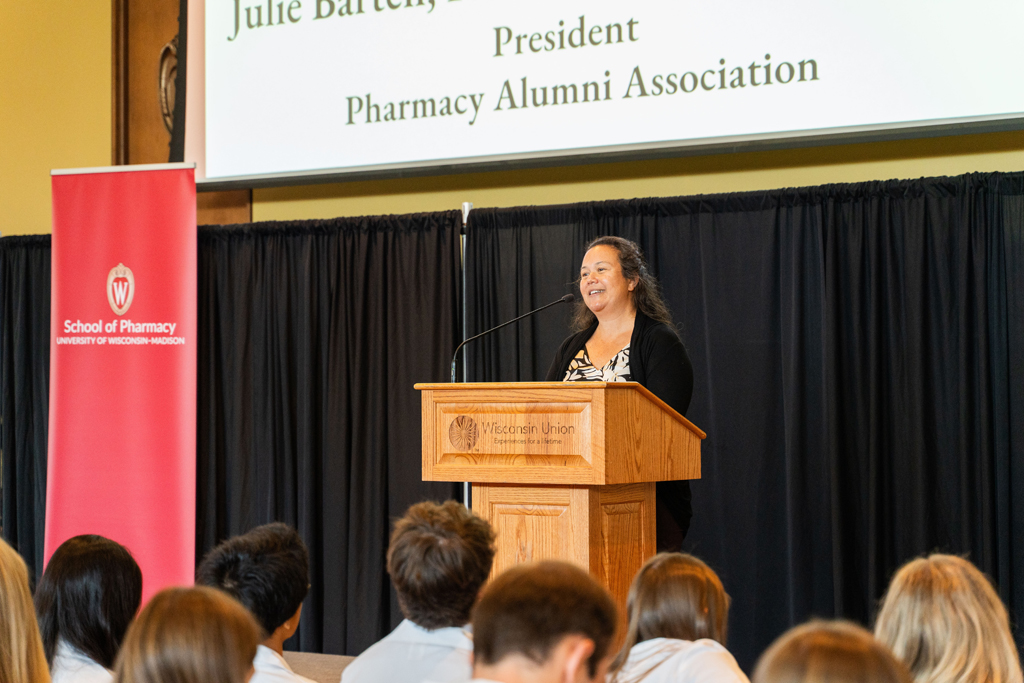 Photo by Paulius Musteikis Julie Bartell speaks at a podium in front of the seated Class of 2028