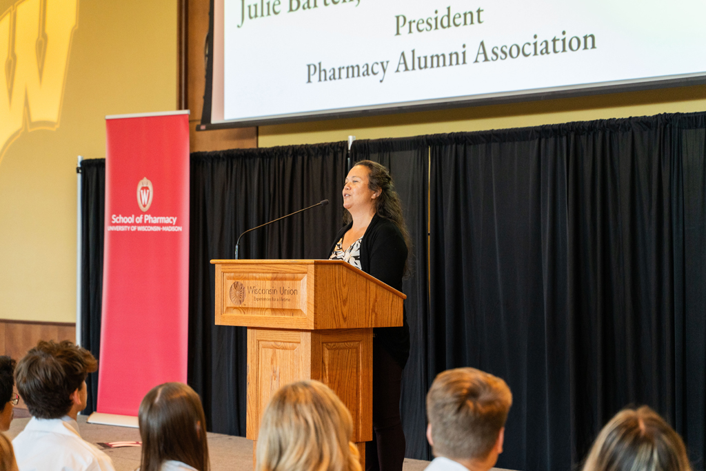 Photo by Paulius Musteikis Julie Bartell speaks at a podium in front of the seated Class of 2028