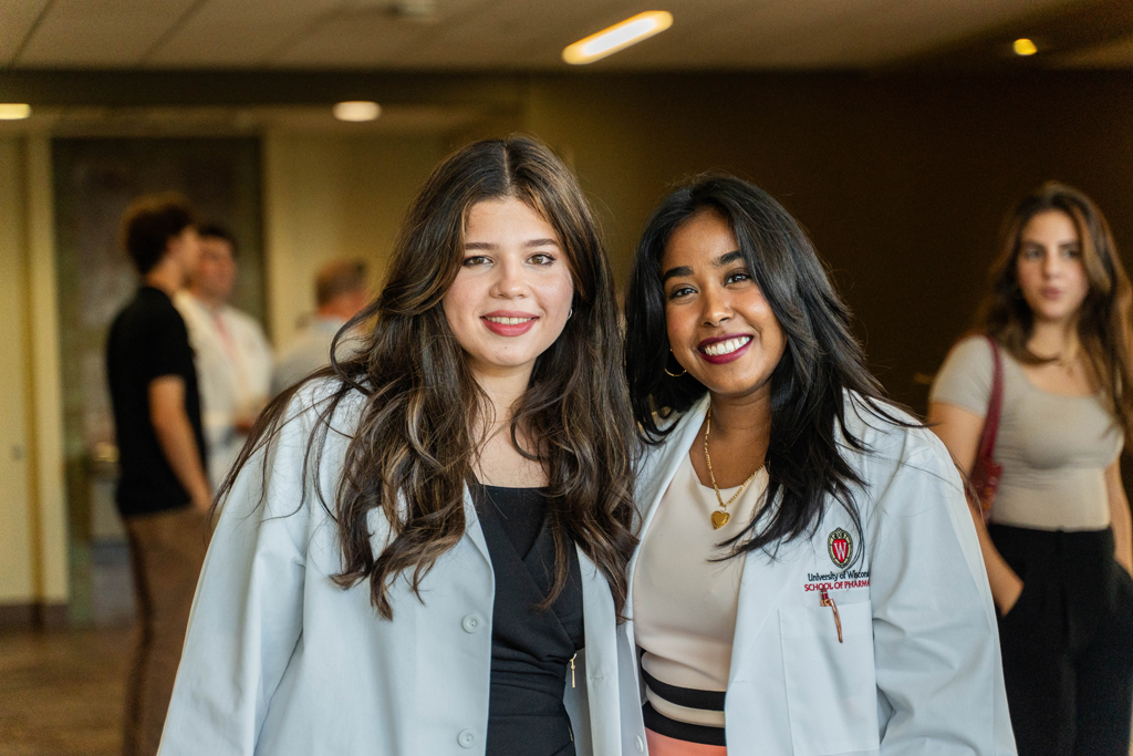 Photo by Paulius Musteikis Two students in white coats pose for a photo
