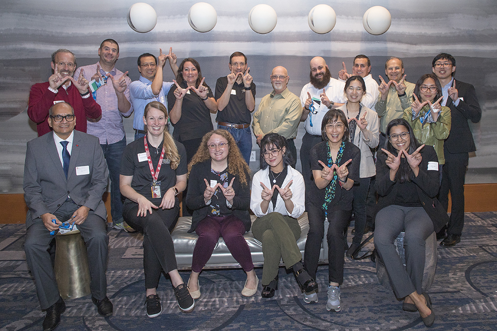055WU-Boston10-17-22-Osberg A group of Pharmaceutical Sciences Badgers holding up "W" hands for Wisconsin.