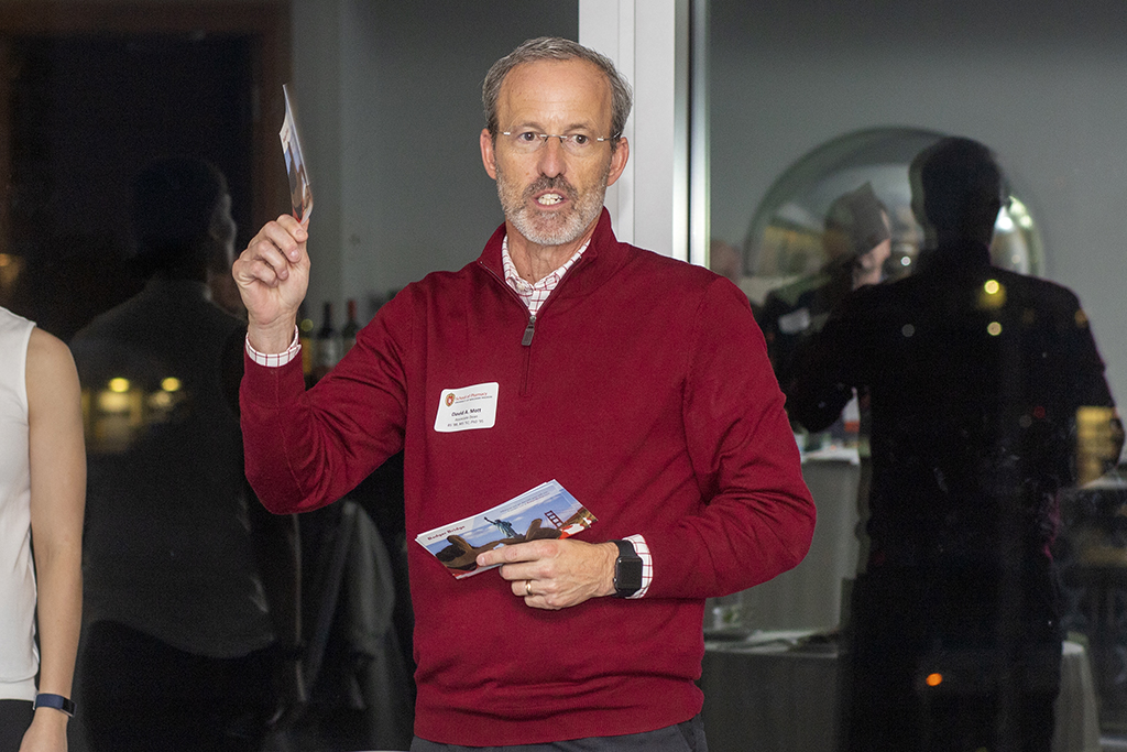 070WU-Boston10-17-22-Osberg Dave Mott holding up Badger Bridge cards for alumni networking.