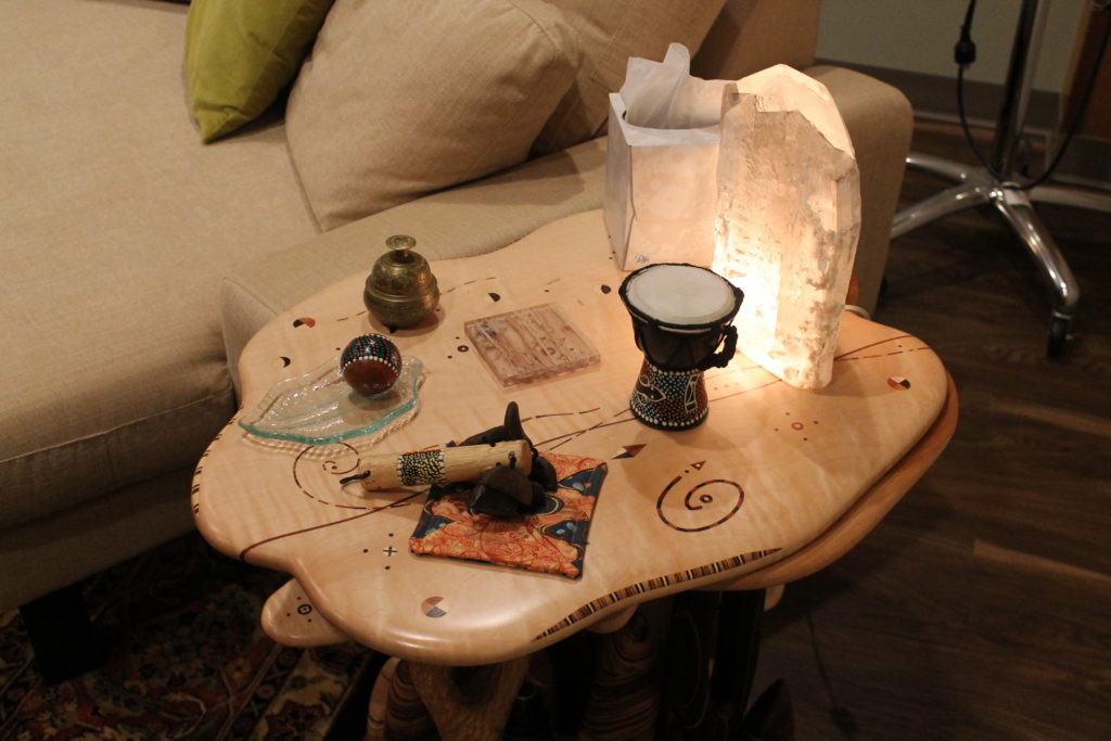 2018-Hutson_Clinical-Therapy-Room-20 Table holding trinkets, tissues, and a crystal lamp in clinical therapy room
