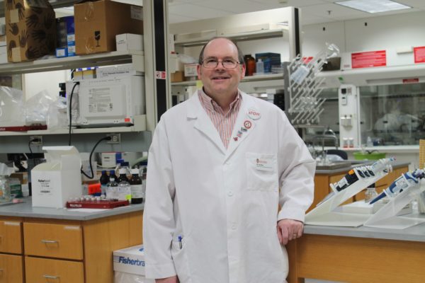 2018-ZStation_lab-057 (1) Ed Elder wearing a white coat in a lab