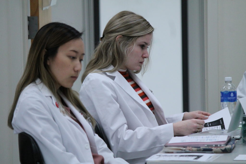 2019-PTx-Asthma-Lab-026 Students looking at papers on table in front of them