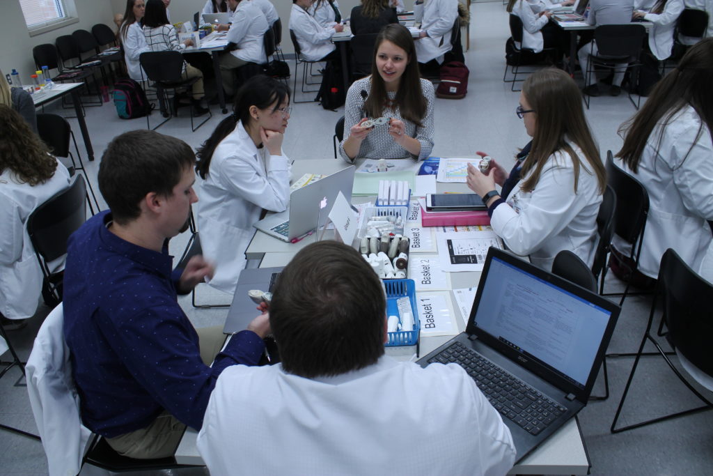 2019-PTx-Asthma-Lab-106 Pharm students looking at asthma medical devices and discussing