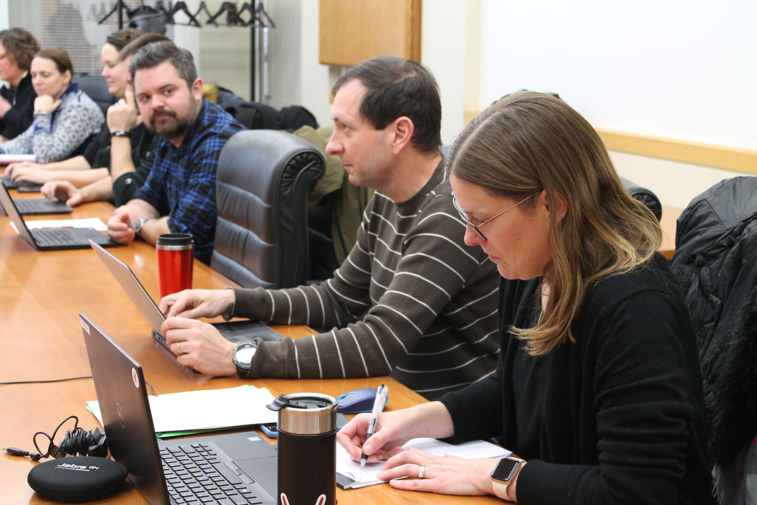 Staff with laptops in front of them during meeting