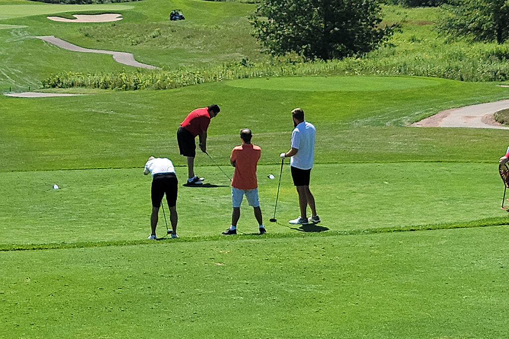 20210813_121232 Pharm alumni on a golf course getting ready to swing