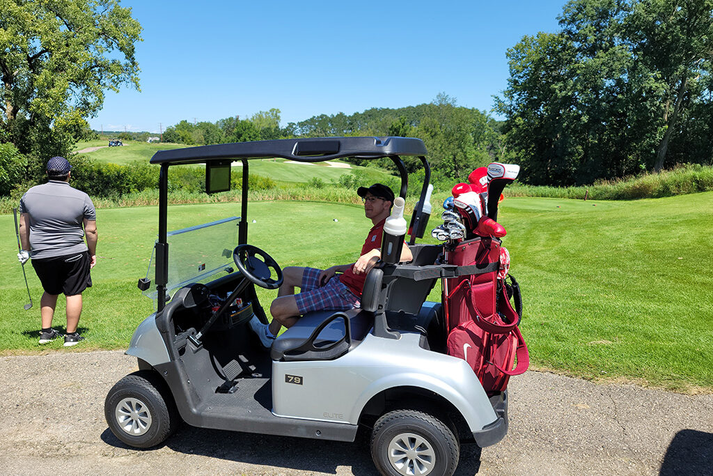 20210813_130025 Pharm Alumni sitting in a golf cart