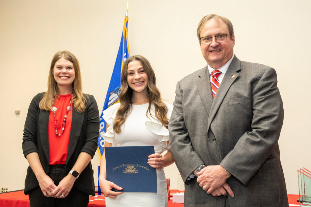 Pharmacy awards May 12, 2023. (Photo © Andy Manis) An award winner poses with Dean Steve Swanson and Andrea Porter.