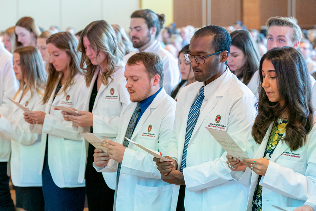 School of Pharmacy White Coat Ceremony Sunday, Sept. 17, 2003. Students in white coats reading their flyers