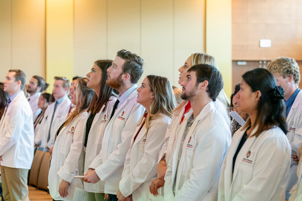 School of Pharmacy White Coat Ceremony Sunday, Sept. 17, 2003. Students in white coats standing from their seats