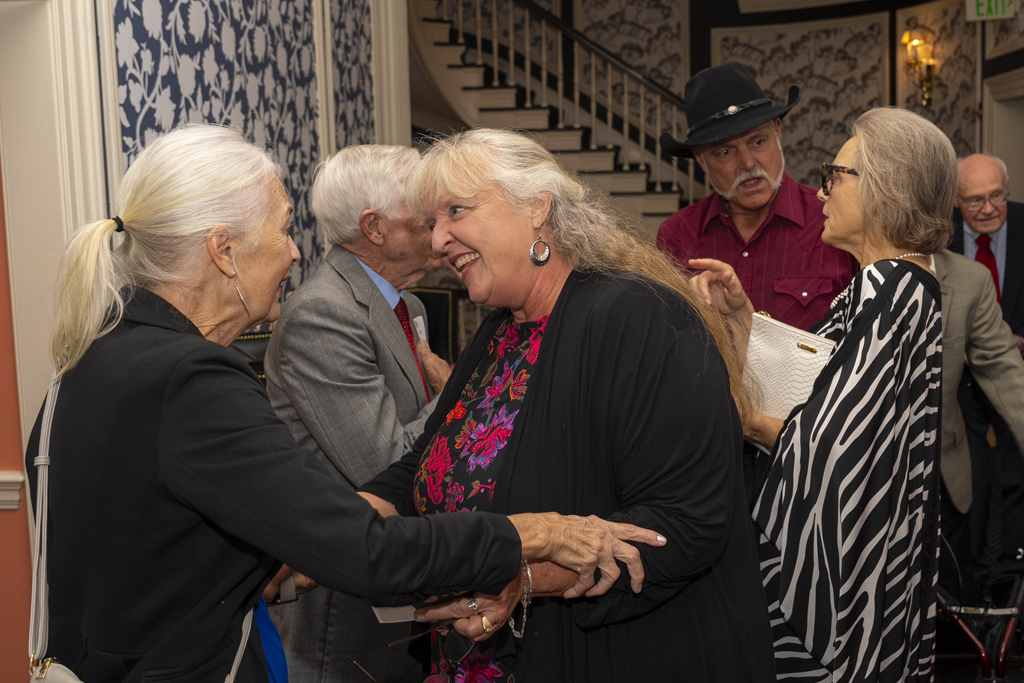 A group of attendees excitedly greet each other