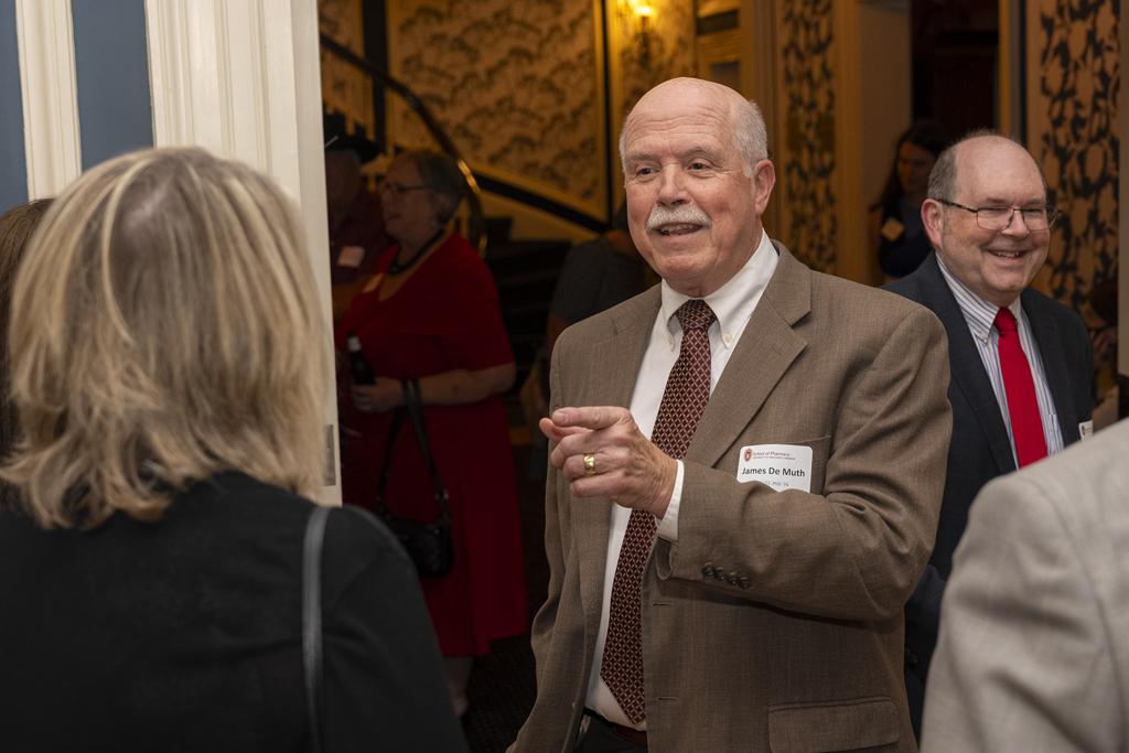 James DeMuth smiles and points to an attendee he's speaking with. Ed Elder smiles in the background