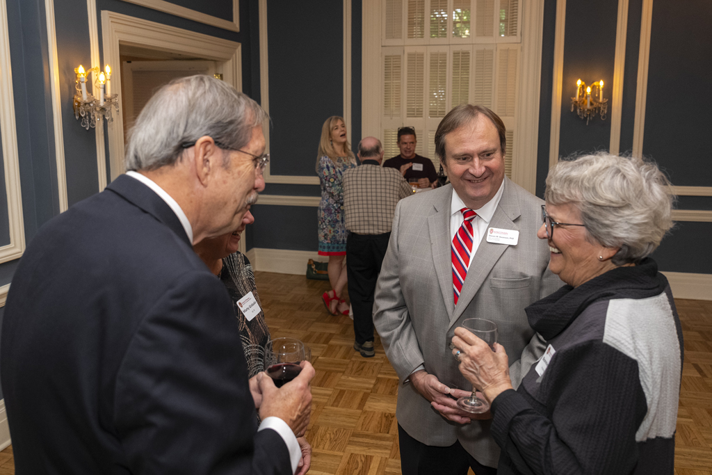 Gary Girdakis and his wife speak with Steve Swanson and another attendee