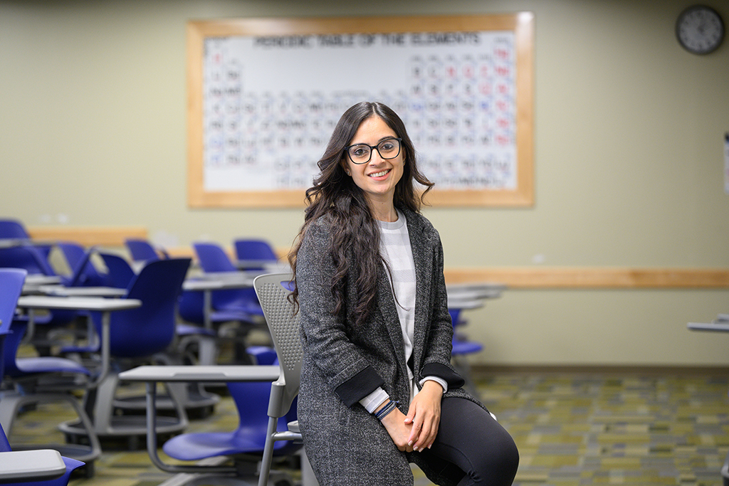Prachi Arora seated on a desk in a classroom