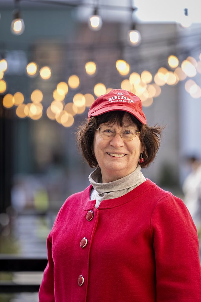 Terri Hix smiles in front of a string of outdoor lights
