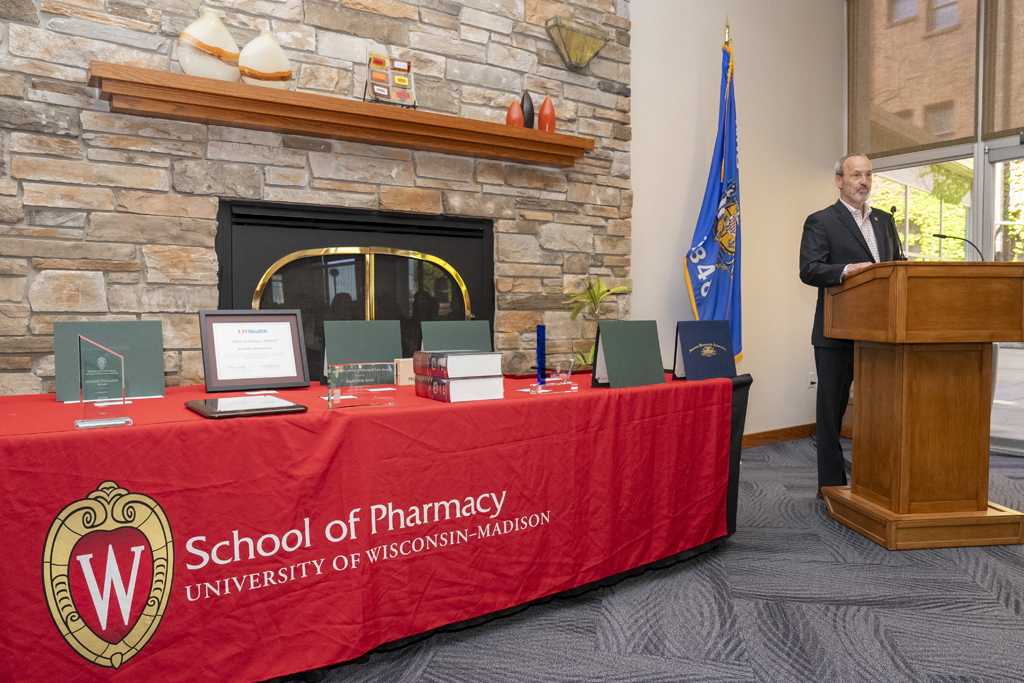 PharmD Graduation Awards Breakfast at the Pyle Center May 10, 2024. Dave Mott speaks at the podium next to a table full of awards