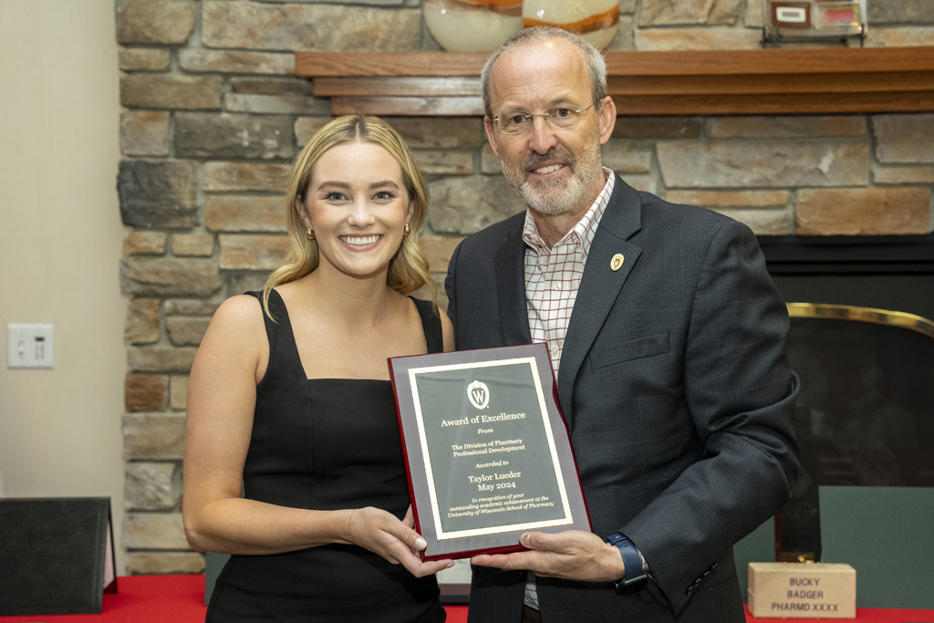 PharmD Graduation Awards Breakfast at the Pyle Center May 10, 2024. Taylor Lueder receives an award from Dave Mott