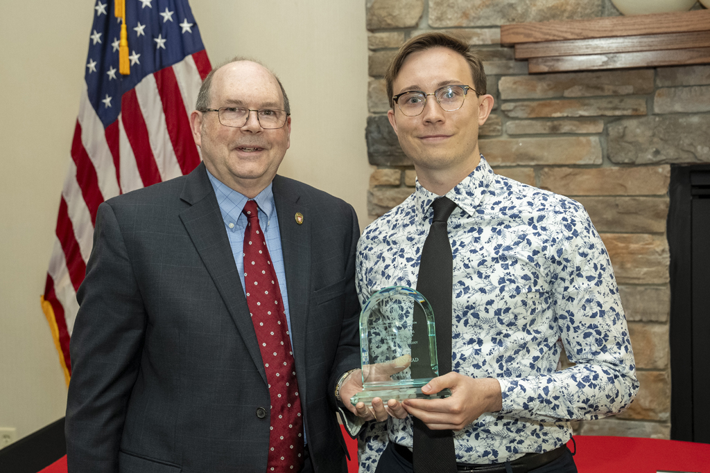 PharmD Graduation Awards Breakfast at the Pyle Center May 10, 2024. A graduate poses with Ed Elder and an award