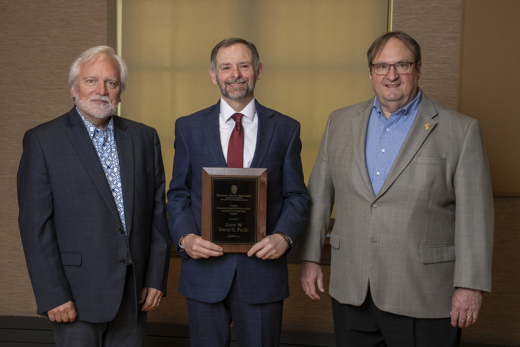 Jeff Johnson, John Davis, and Steve Swanson pose with the PharmTox Alum of the Year Award.