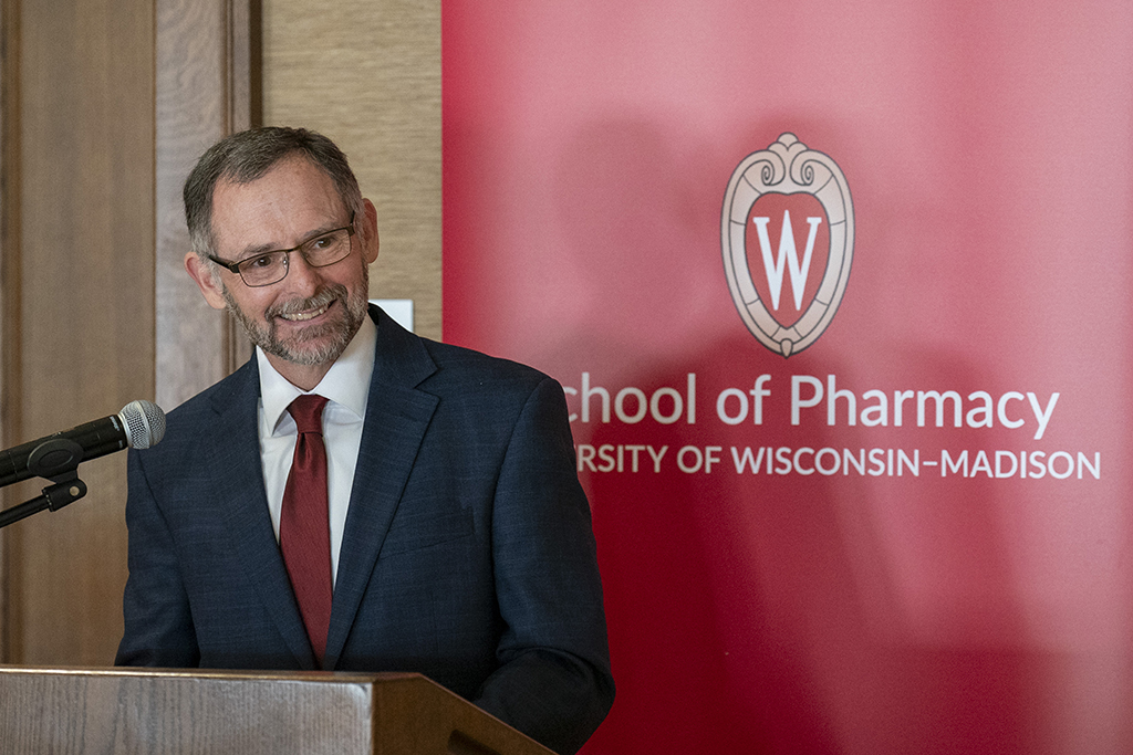 John Davis smiles and speaks at a lectern.