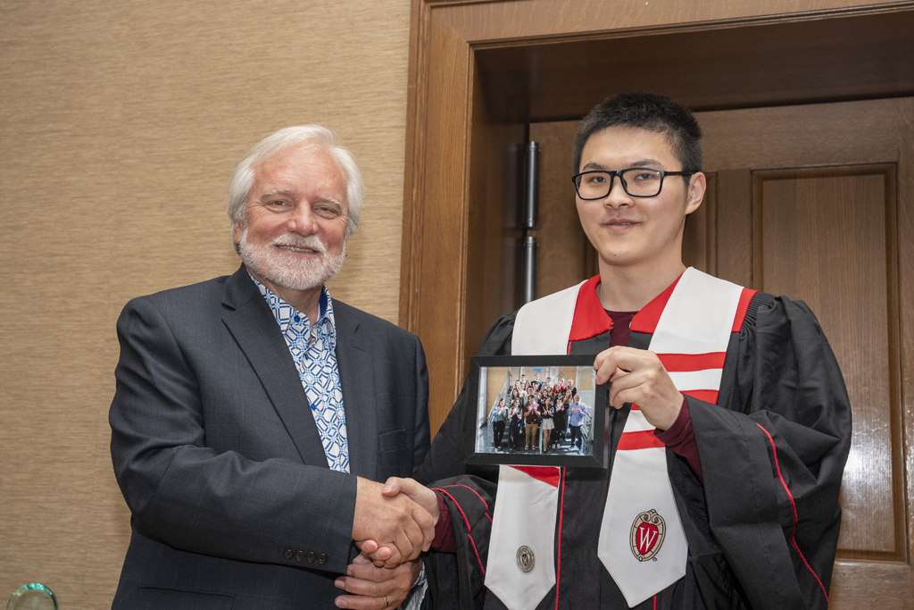 PharmTox Brunch at Carson Gulley May 11, 2024. (Photo © Andy Manis) Ethan Cui accepts a class photo from Jeff Johnson