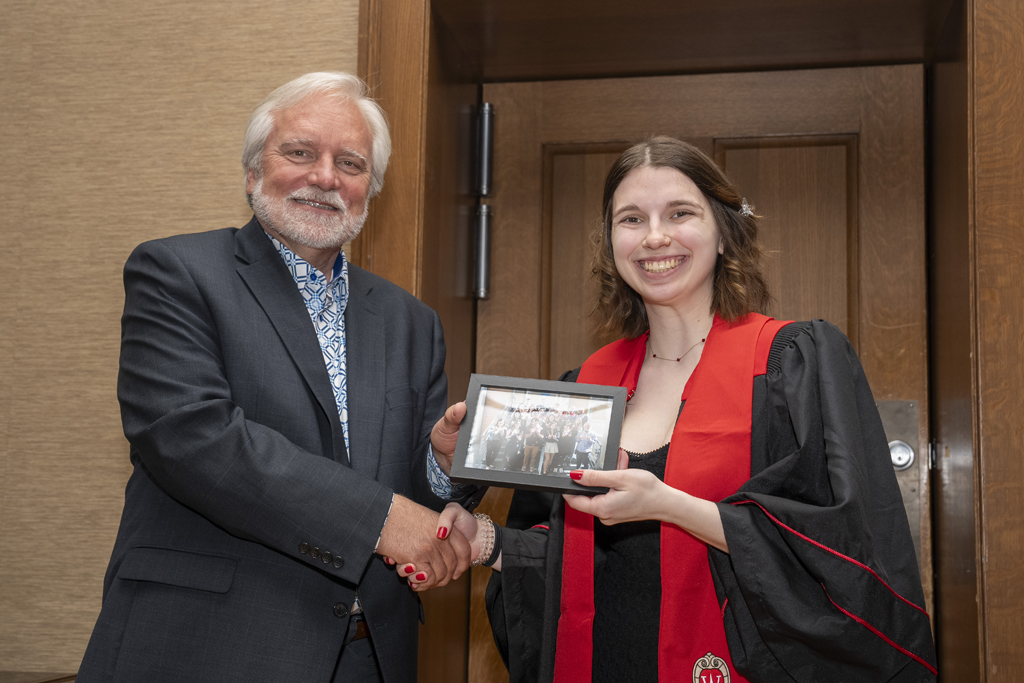 PharmTox Brunch at Carson Gulley May 11, 2024. (Photo © Andy Manis) A student accepts a class photo from Jeff Johnson