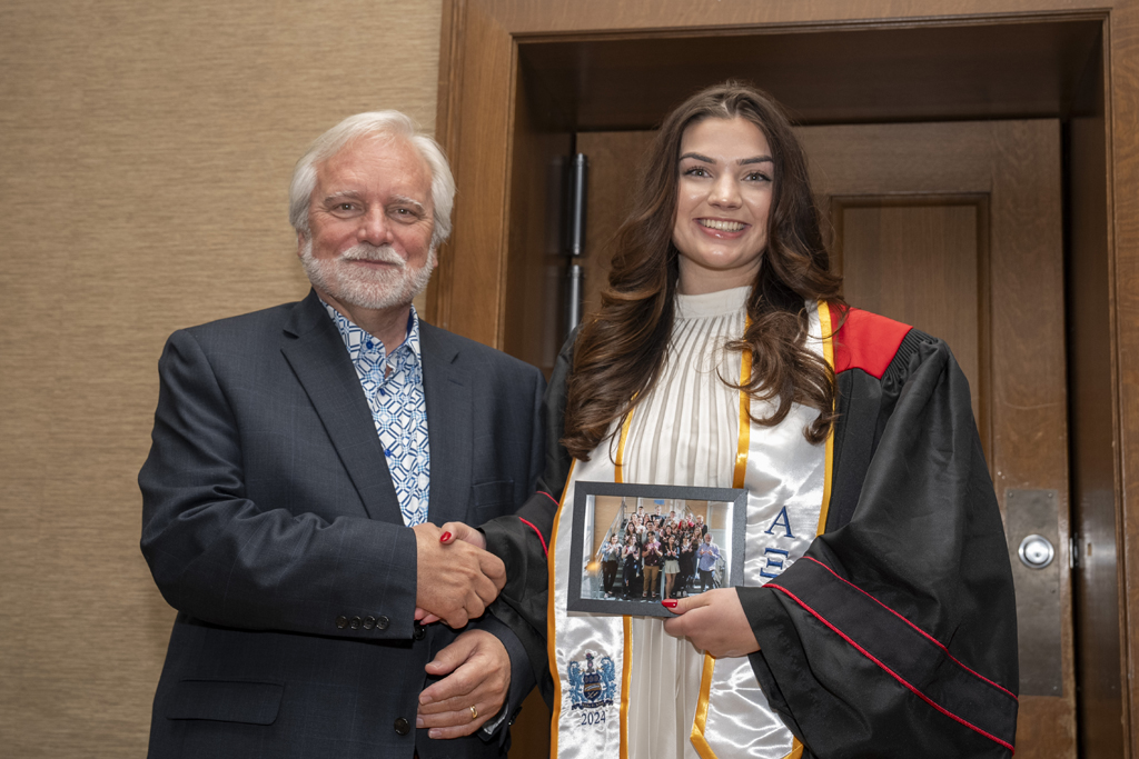 PharmTox Brunch at Carson Gulley May 11, 2024. (Photo © Andy Manis) A student accepts a class photo from Jeff Johnson