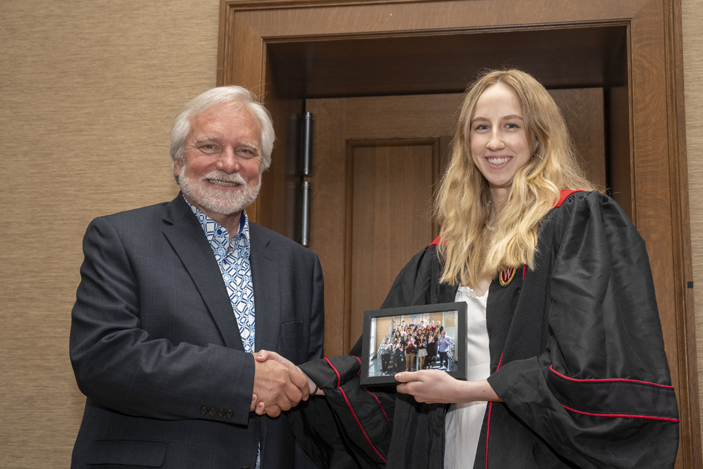 PharmTox Brunch at Carson Gulley May 11, 2024. (Photo © Andy Manis) A student accepts a class photo from Jeff Johnson