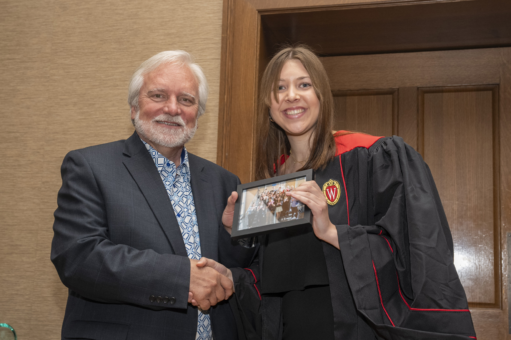 PharmTox Brunch at Carson Gulley May 11, 2024. (Photo © Andy Manis) A student accepts a class photo from Jeff Johnson