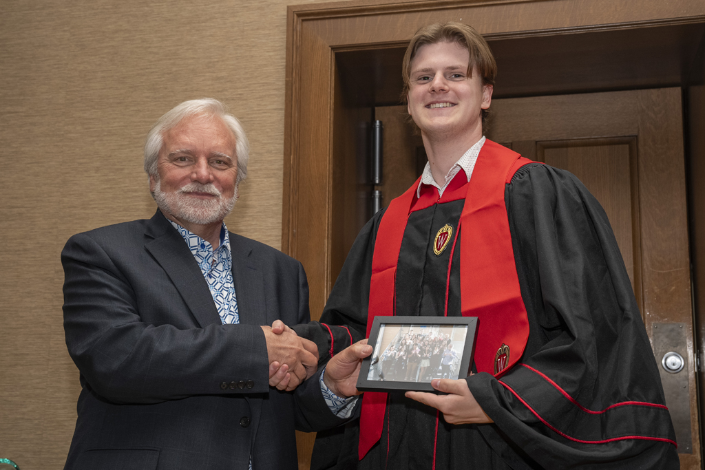PharmTox Brunch at Carson Gulley May 11, 2024. (Photo © Andy Manis) A student accepts a class photo from Jeff Johnson