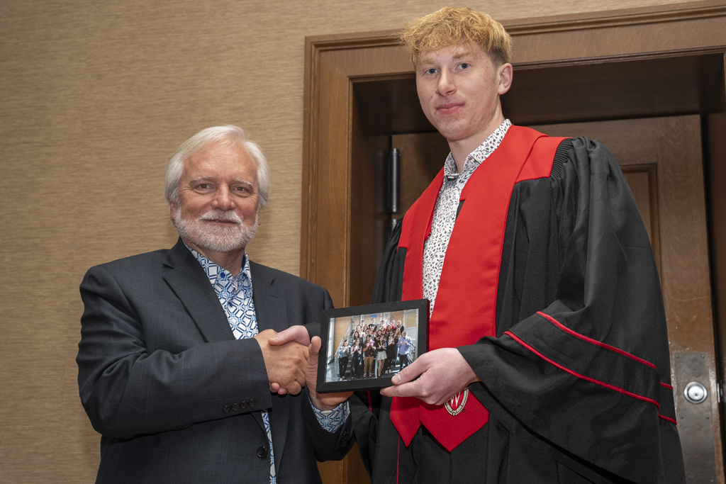 PharmTox Brunch at Carson Gulley May 11, 2024. (Photo © Andy Manis) A student accepts a class photo from Jeff Johnson