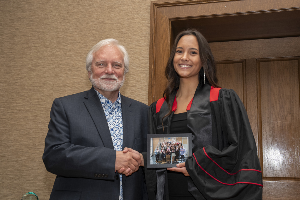 PharmTox Brunch at Carson Gulley May 11, 2024. (Photo © Andy Manis) A student accepts a class photo from Jeff Johnson