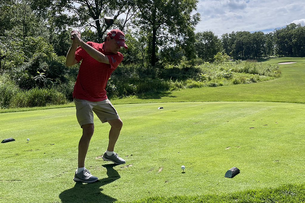 6B96B5DA-B6CB-494C-A1DA-C5ED42C5D061 An alum taking a swing on the green.