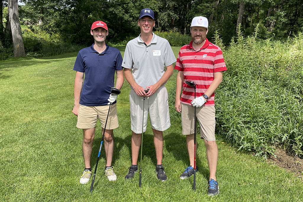 9518DDD1-EB91-4EA8-A8D8-219AC15A932B A group of alumni smile at the 2022 golf outing, outside in the sun