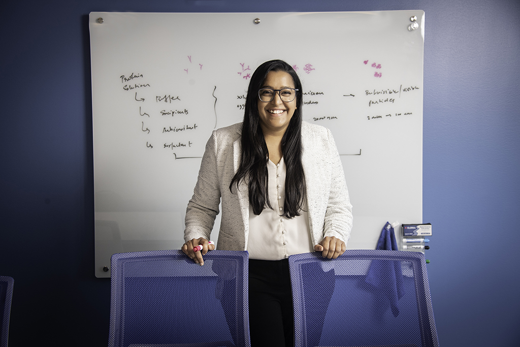 Portrait of Ashita in front of a white board marked with information