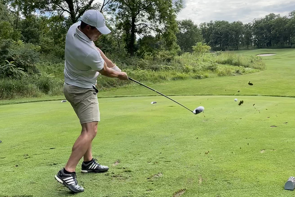 B95508AD-CC9E-44EF-B884-702552A86274 An alum taking a swing on the green.